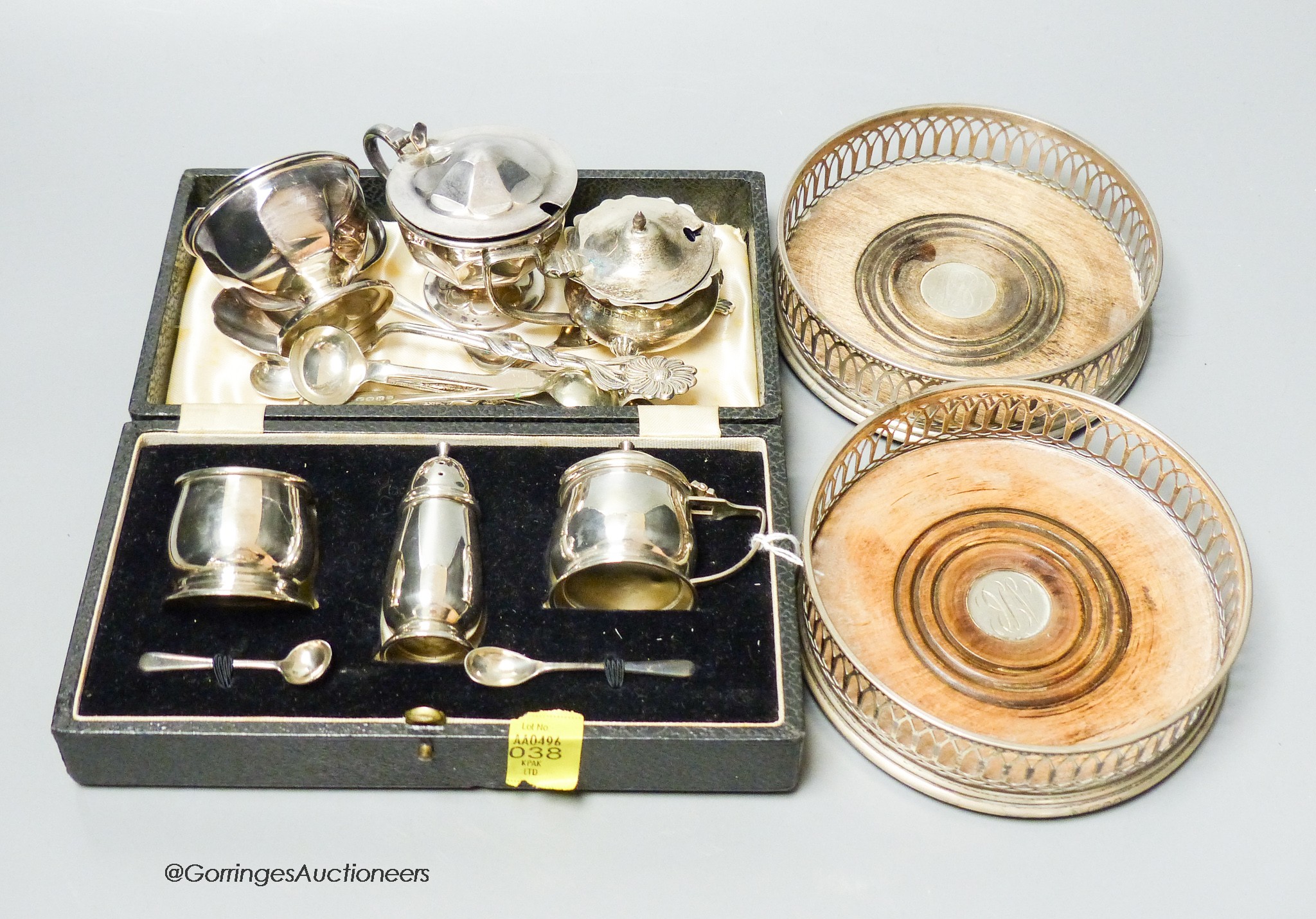 A modern pair of silver wine coasters, a cased silver condiment set and plated items.